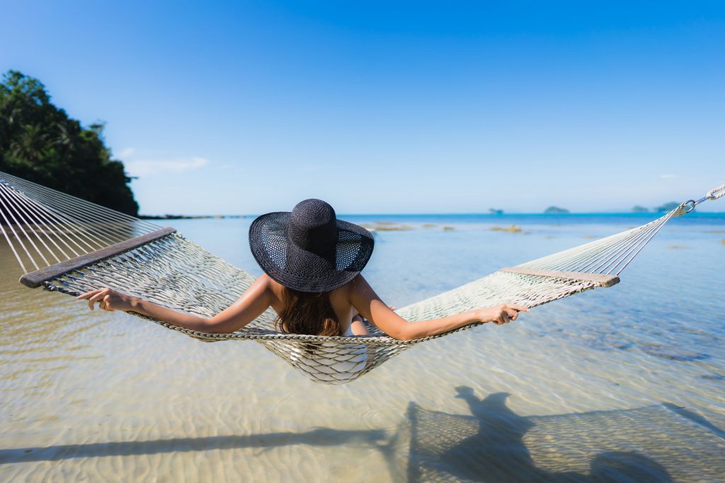 woman on vacation swinging over the sea